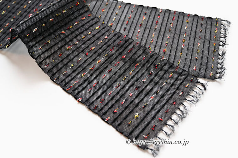 誉田屋源兵衛　半幅帯（芭蕉段織/黒橡・赤黄白ネップ）