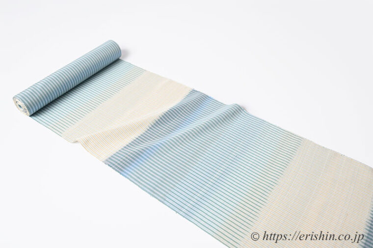 芝崎圭一　座繰紬（絣・多色暈し段/鳥の子色に薄花色のさざ波段）「着物と帯・呉服えり新」