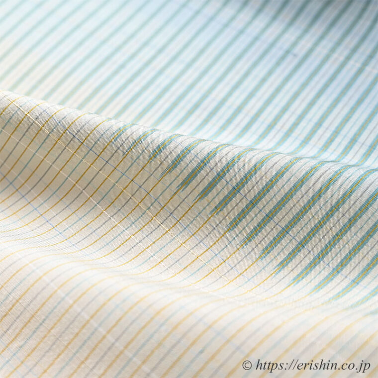 芝崎圭一　座繰紬（絣・多色暈し段/鳥の子色に薄花色のさざ波段）「着物と帯・呉服えり新」