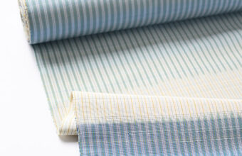 芝崎圭一　座繰紬（絣・多色暈し段/鳥の子色に薄花色のさざ波段）「着物と帯・呉服えり新」